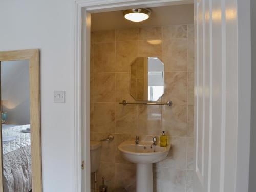un baño con lavabo y espejo en Upper Floors At The Lawns, en Filey
