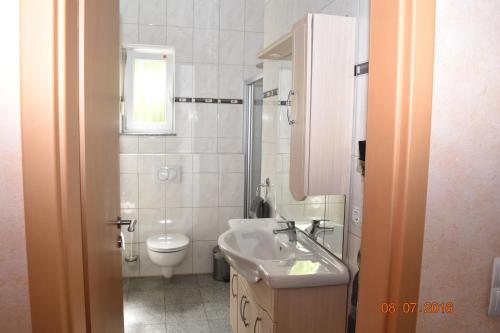 a bathroom with a sink and a toilet at Ferienweingut Borens in Wiltingen
