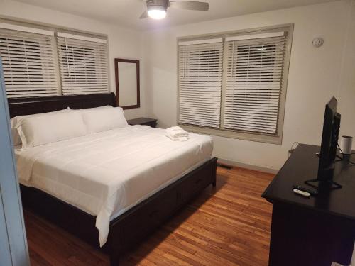 a bedroom with a bed and a desk and two windows at Cozy Albemarle 1 BR- EV charging in Albemarle
