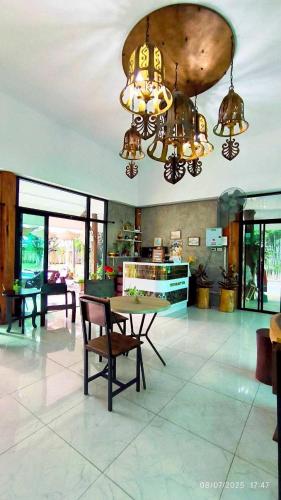 a dining room with a table and a chandelier at The forest hill cafe&homestays Chiangmai in Ban Muang Len