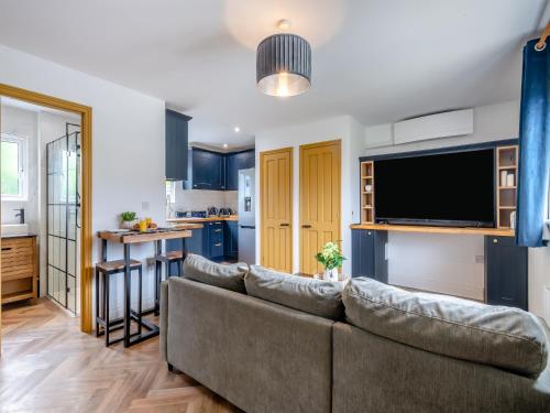 a living room with a couch and a kitchen at The May Tree in South Creake
