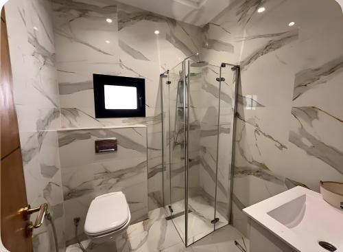 une salle de bain avec douche et WC et une télévision dans l'établissement Villa Bianca, à Sidi Jedidi