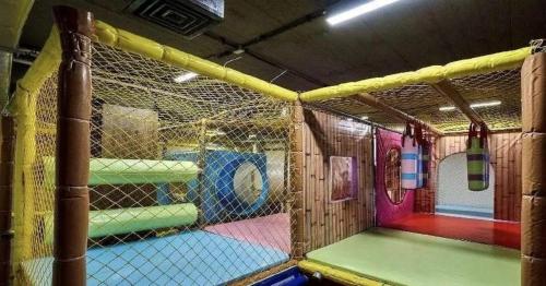 Una jaula de bateo en un patio de recreo con equipos de juego coloridos. en Apartament Białka Tatrzańska A&M, en Białka Tatrzanska