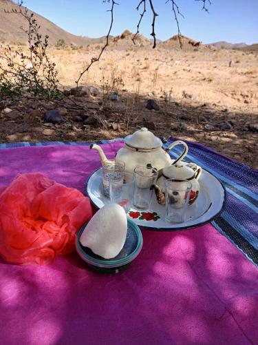 una mesa con un juego de té sobre una manta morada en Agoudim Nikhartan, en Tinerhir