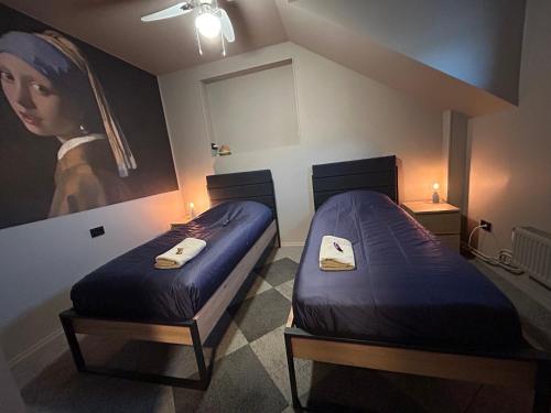 two beds in a room with a painting on the wall at Traditional Narva House in Narva