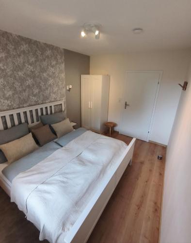 a bedroom with a large white bed in a room at Ferienwohnung Waldgeflüster in Melle