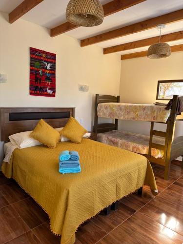a bedroom with a bed with two blue towels on it at Hostal Inti Wasi in San Pedro de Atacama
