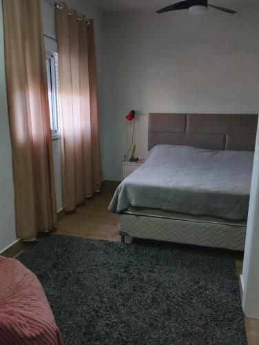 1 dormitorio con cama, ventana y alfombra en Sobrado Cinza com Hidromassagem, en São Lourenço do Sul