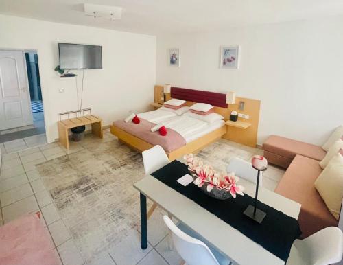 a bedroom with a bed and a table and a couch at Alpesi Apartman Downtown in Sopron