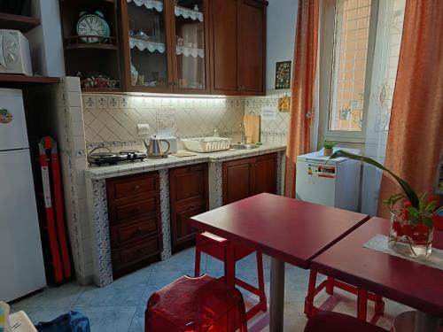 une cuisine avec une table rouge et une table et un réfrigérateur dans l'établissement Casavamica, à Rome