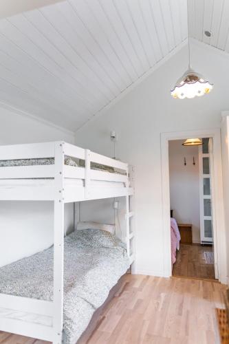 a bedroom with a bunk bed in a white room at Toftenäs gästhus in Toftenäs