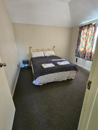 a bedroom with a bed with two towels on it at Chriatcurrch Best Home in Christchurch