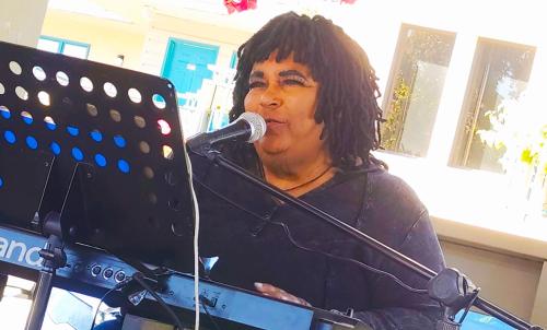 鸽子谷阿伯斯登岛酒店及套房的一名男子在键盘前对着麦克风唱歌