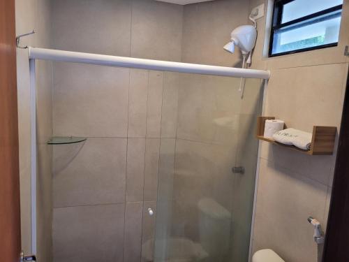 a shower with a glass door in a bathroom at Flat Casa da Praia in Porto De Galinhas
