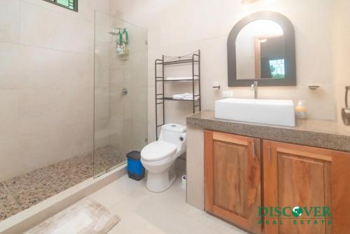 a bathroom with a toilet and a sink and a shower at Nica Nest 3Br Eco Home Escamequita, NI in San Juan del Sur