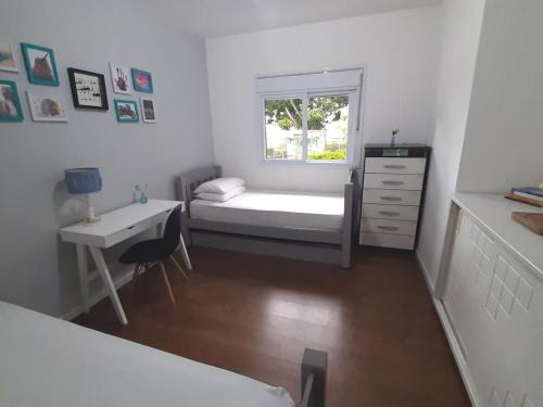 アチバイアにあるCasa Varanda Por do Sol - Piscina Climatizada - Dentro da Cidadeのベッドと机と窓のある寝室