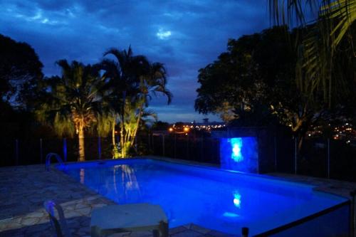 アチバイアにあるCasa Varanda Por do Sol - Piscina Climatizada - Dentro da Cidadeの夜間のスイミングプール(照明付)