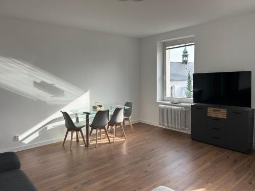a dining room with a table and chairs and a window at Apartmán 28 in Horní Město