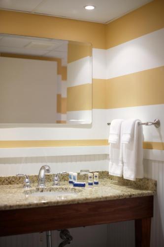a bathroom with a sink and a mirror and towels at Pan American Oceanfront Hotel in Wildwood Crest