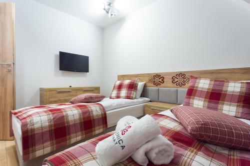 a bedroom with two beds and a tv on the wall at Parzenica B&B - Wyjątkowa i Jedyna!!! Sprawdź nas a nie pożałujesz! in Białka Tatrzanska