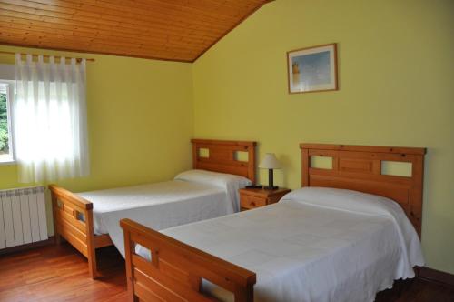 2 camas en una habitación con paredes verdes en Casa Polín, en Las Herrerías