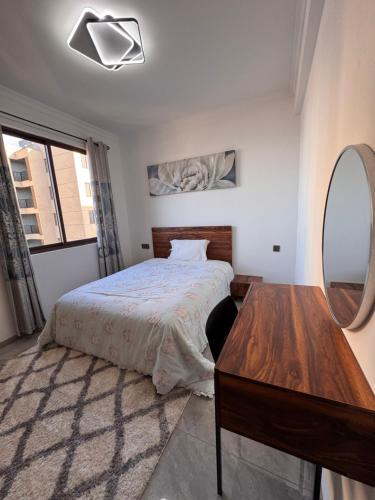 une chambre avec un lit, un miroir et une table dans l'établissement Kipé Plaza platinium Vue Mer Appartement 2 Chambres, à Conakry