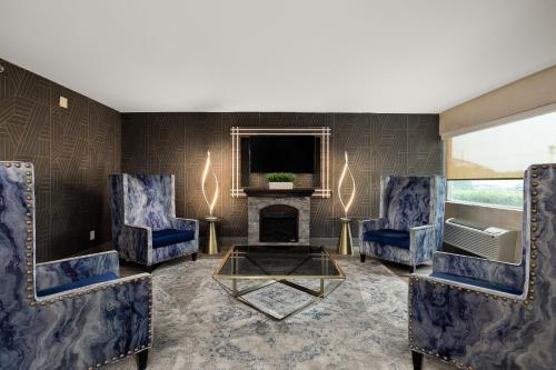 a living room with two blue chairs and a fireplace at Verta Hotel McAllen Airport in McAllen