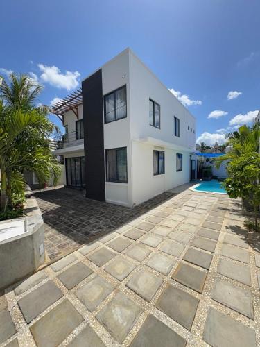 a large white house with a pool in front of it at Mimi villa in Port Louis