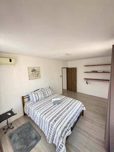 a bedroom with a large bed with a striped comforter at Mimi villa in Port Louis