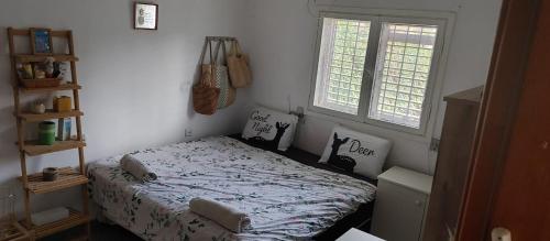 a bedroom with a bed and a window at בית פרטי כפרי בהרצליה in Herzelia 