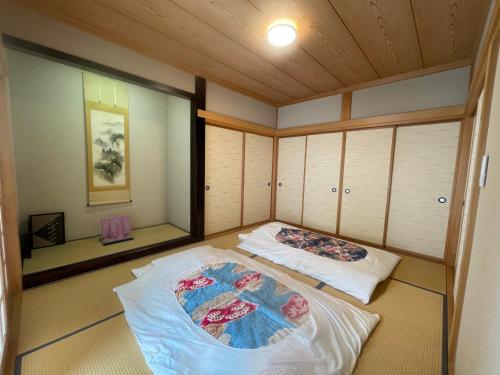 una habitación con dos camas en la esquina de una habitación en 富士view 5LDK 河口湖駅まで徒歩圏内 最大10名で一棟貸し, en Fujikawaguchiko