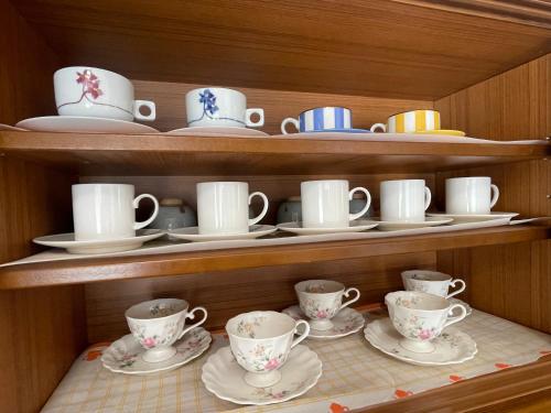 Un armario con platos, tazas y platillos. en 富士view 5LDK 河口湖駅まで徒歩圏内 最大10名で一棟貸し, en Fujikawaguchiko