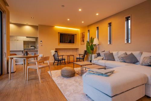 a living room with a white couch and a table at MIRISE Sky Villa & Sauna in Minakami