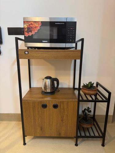 eine Mikrowelle auf einem Holzständer in der Unterkunft Maa in Dhaka