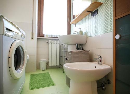 une salle de bain avec un lavabo et une machine à laver dans l'établissement Corno Piccolo [cozy home in L’Aquila city center], à LʼAquila