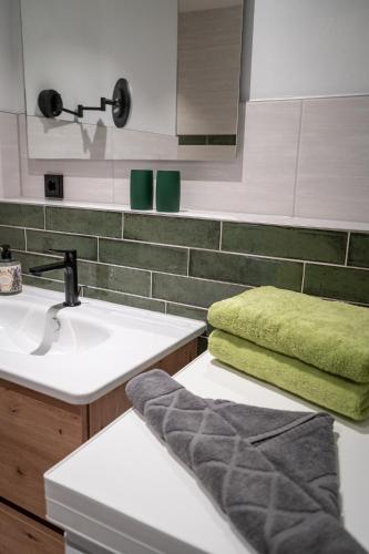 a bathroom with a sink and a green towel at Eiche - Ferienwohnung in Dötlingen mit Waldblick in Dötlingen