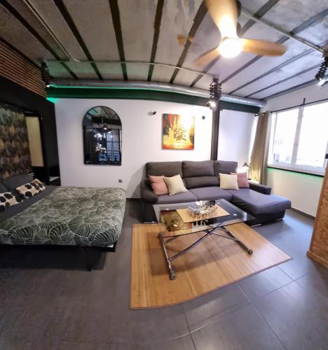 a living room with a couch and a table at Estudio PIZARRO DOWN TOWN in Torremolinos