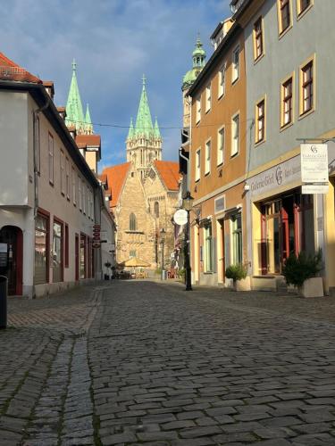 a cobblestone street in a town with a cathedral at Joe's Home Naumburg -modern,vintage Apartment in Naumburg