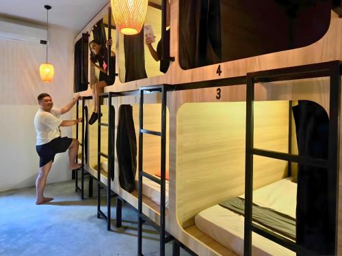 Un hombre en una habitación de albergue con literas. en THE PLACE Hostel Phnom Penh, en Phnom Penh