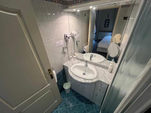 a bathroom with a sink and a mirror at Hôtel Riquet in Toulouse