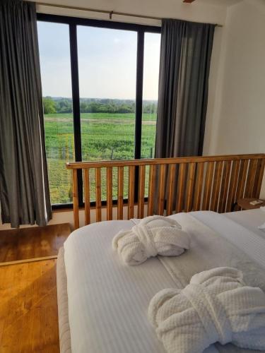 a bedroom with a bed and a large window at Natura Bungalow in Ždrelo
