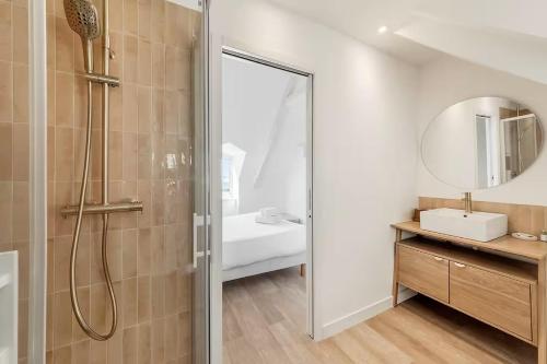 ein Badezimmer mit Dusche, Waschbecken und Spiegel in der Unterkunft Bord De L'Eau 3 et 6 in Cancale