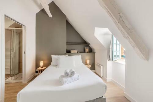 ein Schlafzimmer mit einem weißen Bett mit zwei Handtüchern darauf in der Unterkunft Bord De L'Eau 3 et 6 in Cancale