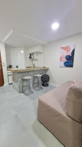 een woonkamer met een bank en een keuken bij Residencial Pasárgada, apto 602 in Vila Velha