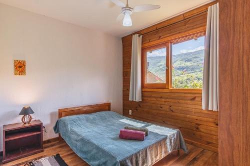 a bedroom with a bed and a window at Refugio Macacu com Vista para Montanhas in Siriú