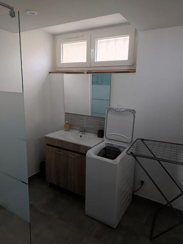 a small bathroom with a sink and a window at Appartement Cosy chez Nicolas et Aline in Pompiey