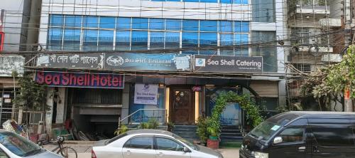 a street with cars parked in front of a building at Sea Shell Hotel - Sales & Booking Office in Bāiljuri