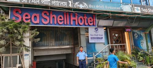 a police officer standing in front of a seafood shell hotel at Sea Shell Hotel - Sales & Booking Office in Bāiljuri