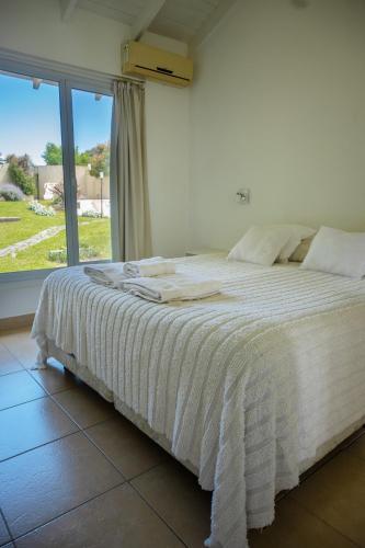 a bed in a room with a large window at Altos de Ventana in Sierra de la Ventana