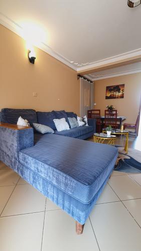 a living room with a blue bed and a couch at Serenity Homes in Kampala